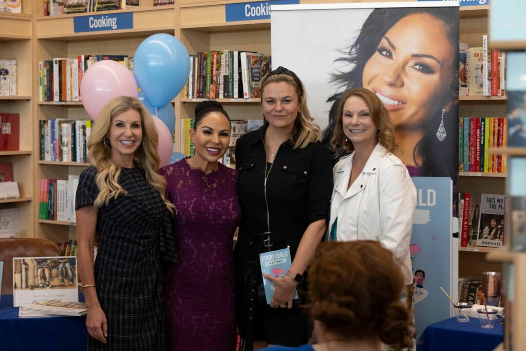 Jacqelle Lane posing with a group of woman on an event for her book "Every Child Matters" - jacqelle lane