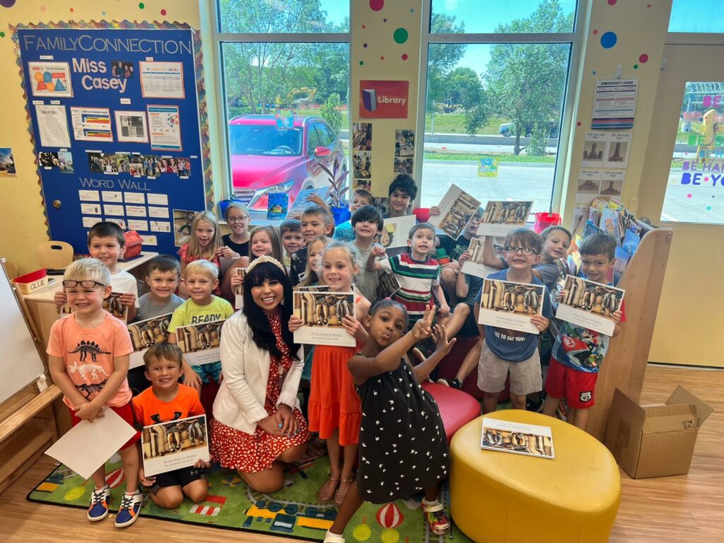 Jacqelle Lane posing with a group of children in a classroom, some children are holding the book "From Bully to Bestie" - jacqelle lane
